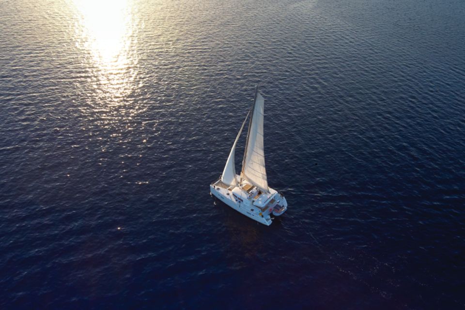 Santorini: Platinum Catamaran Cruise W/ BBQ Meal & Open Bar - Sailing Along Santorinis Coastline